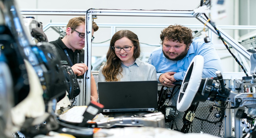 a woman and two men who are engineers in the workplace